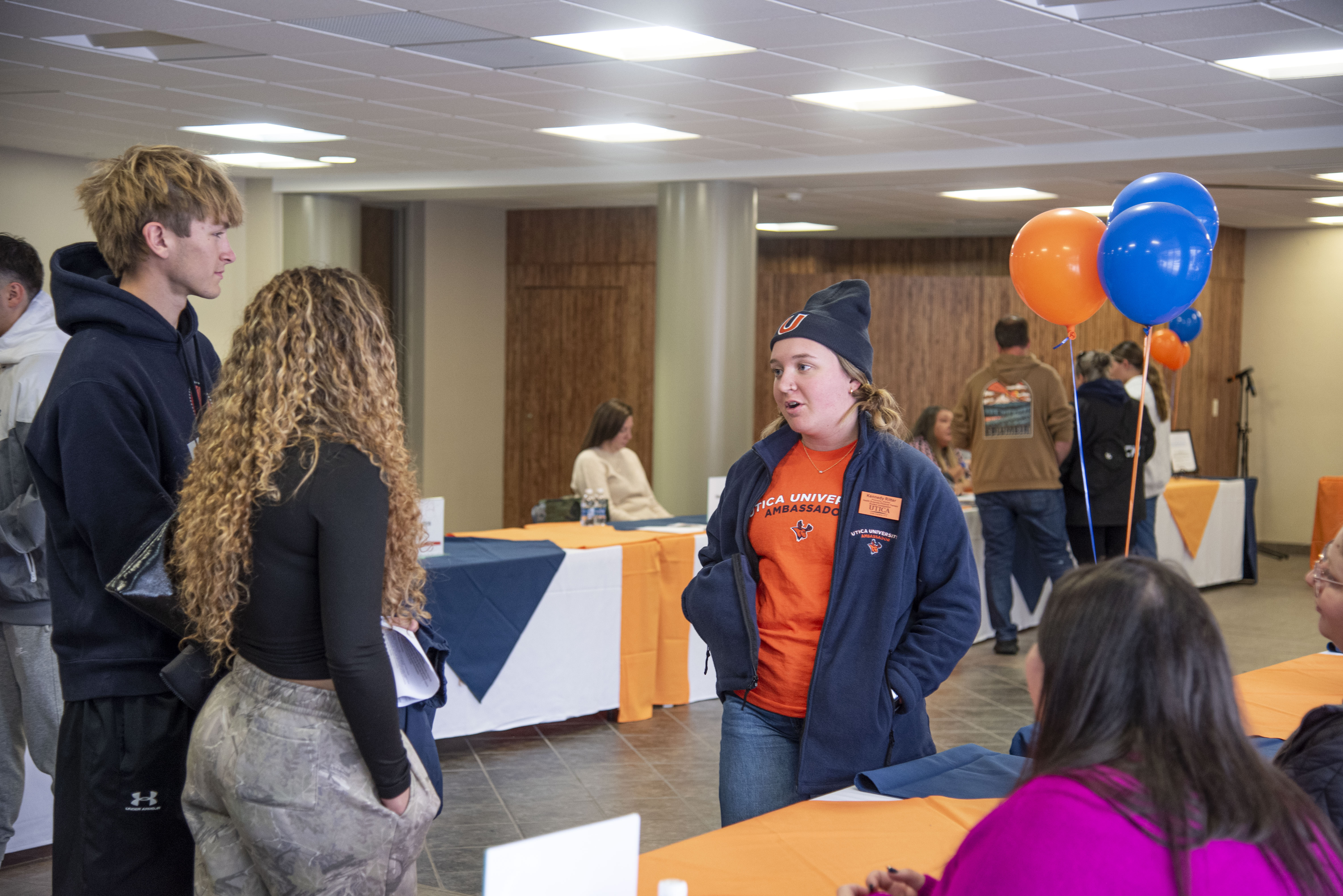 Prospective students chat with members of the Utica community at a November 2025 Open House event.