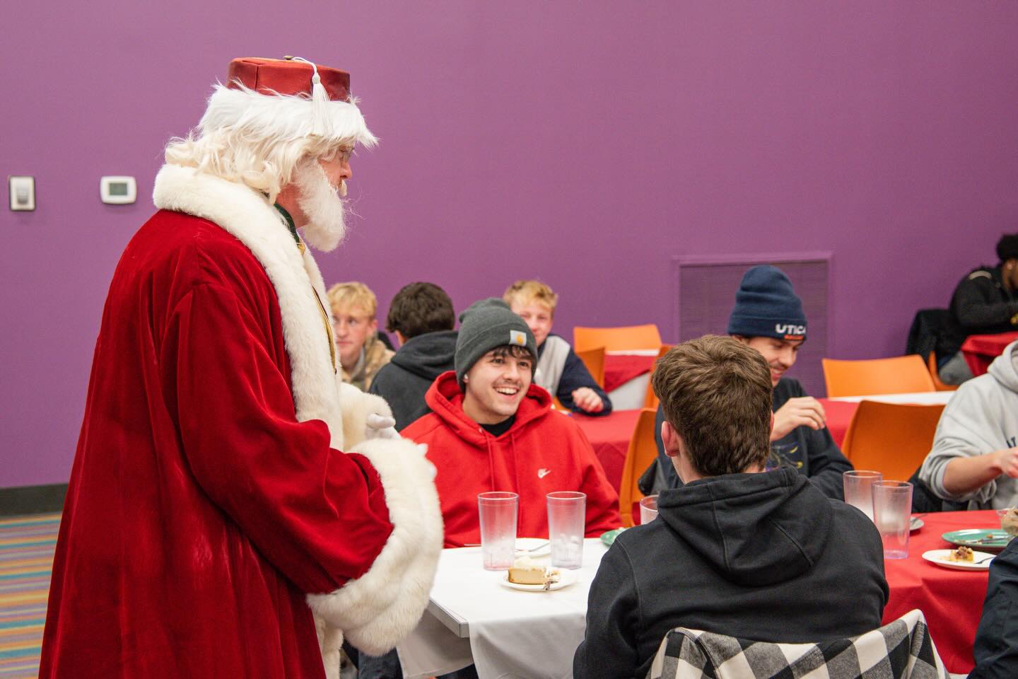 Santa Claus visits with students at the 2025 Holiday Dinner.