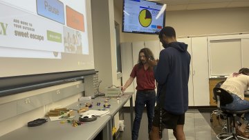 A student works with Professor Jonathan Gaffney on a Physics project in class.