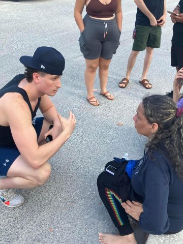 Conner Crossley '26 speaking with mother of the person he saved from drowning at Turtle Beach, Florida.