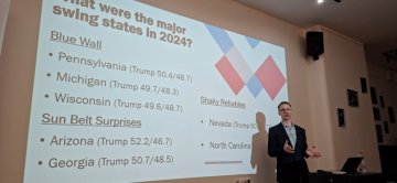 Professor Luke Perry lectures in front of a slide presentation at the University of Debrecen in Eastern Hungary.